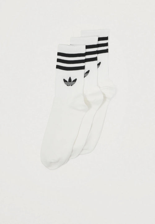 Three pairs of white athletic socks featuring black stripes and a small dark logo. Ribbed texture, ankle length design.