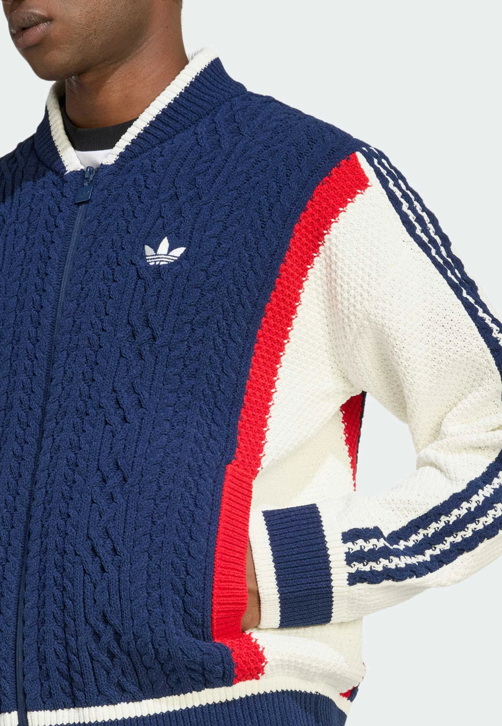 Giacca a zip in maglia blu navy e bianca con accenti rossi, polsini a coste e un piccolo logo bianco. Il motivo testurizzato mette in risalto il design.